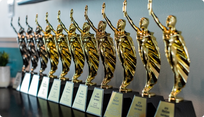 A row of eight MarCom Awards: three platinum awards and five gold awards.